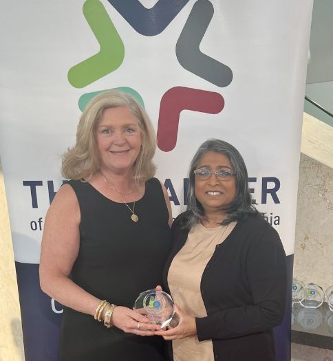 Helen Hammerschmidt and Dr. Rita Patel-Eng holding Civic50 award in front of  Philadelphia Chamber banner