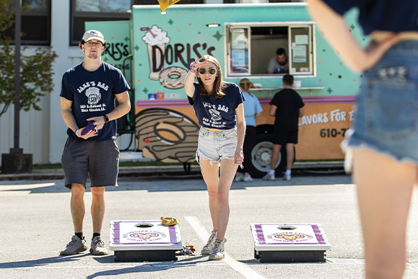 Two people are playing a game of cornhole