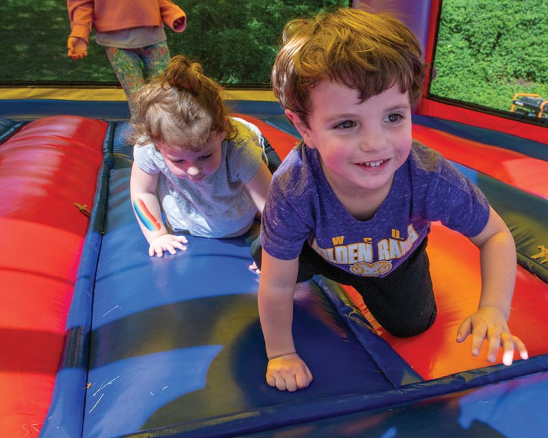 2 toddler age kids playing in the moonbounce