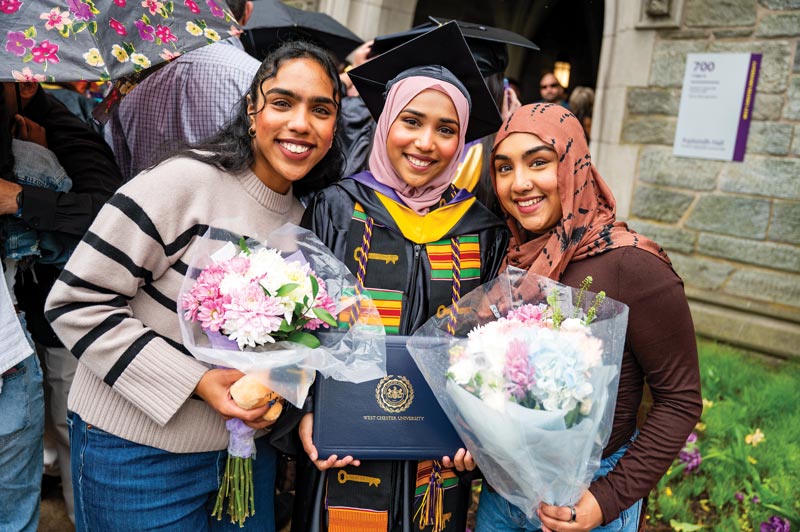 3 women pose and hold flowers 
