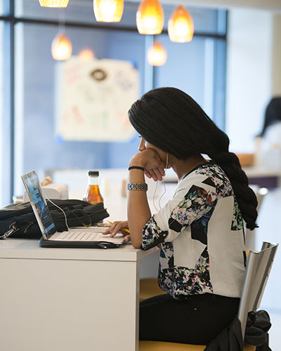 Student eating and working in dining hall